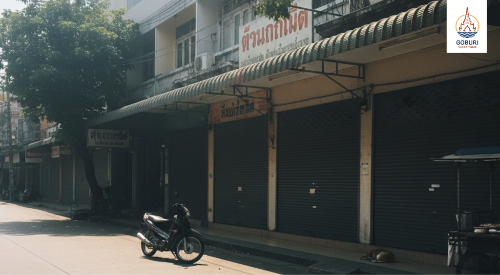 A quiet street in Surat Thani during the afternoon heat, illustrating the local pace of life and commercial rhythms.